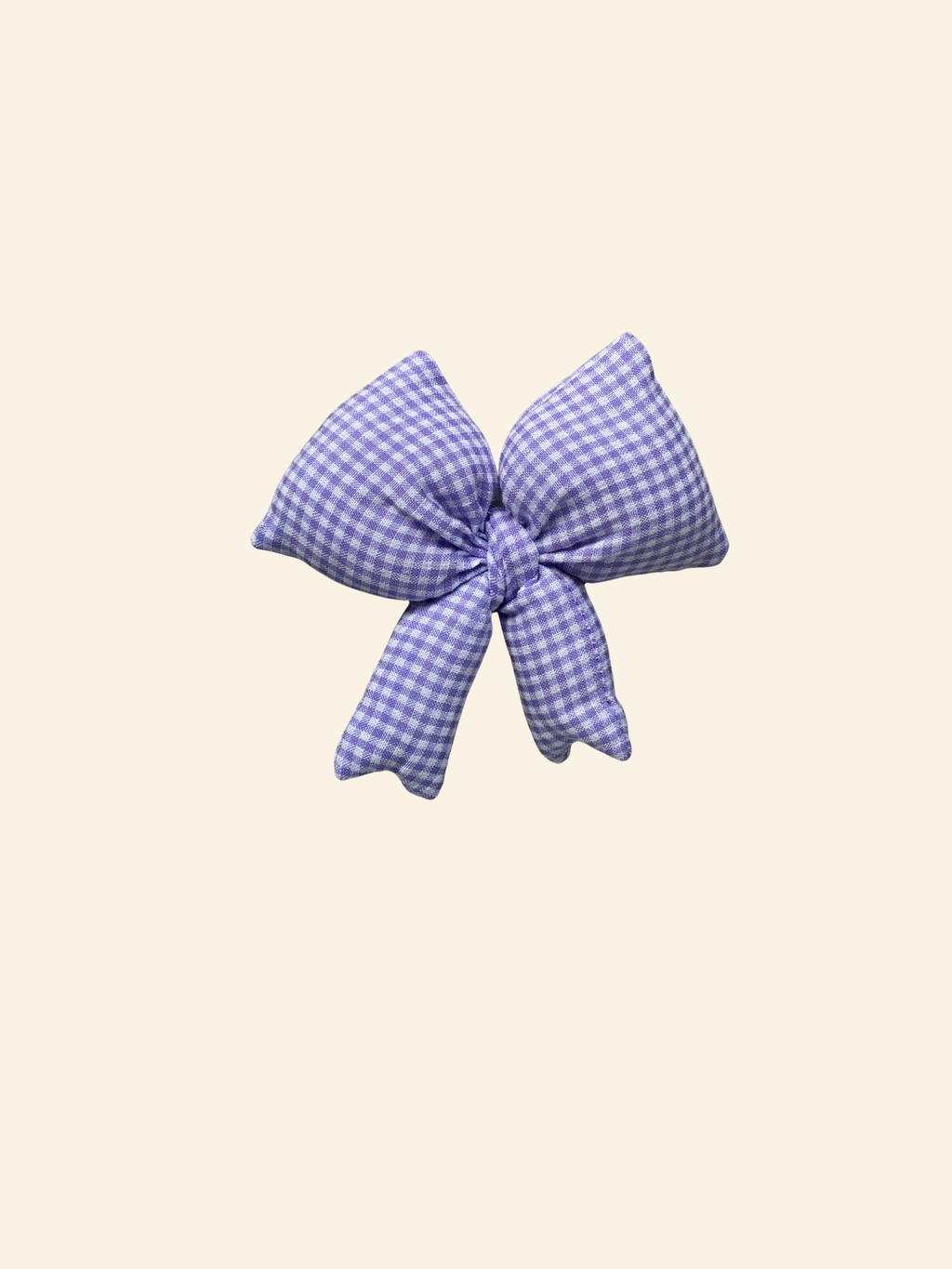 Purple and white checkered puffy bow on a cream background